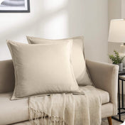 Two matching pillow shams with pillows inside on a couch