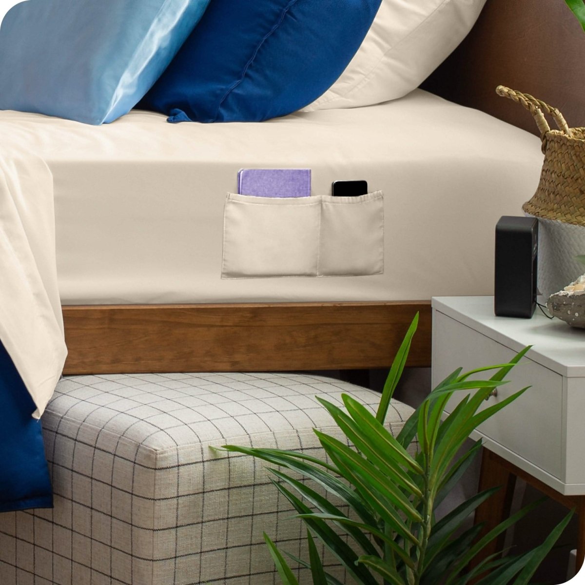 Close up of pockets on a fitted sheet with a remote and phone in the pockets