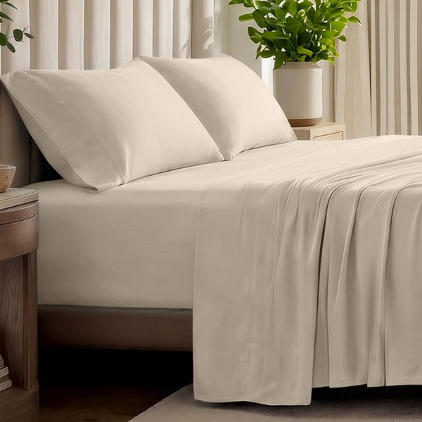Organic jersey bed sheets and pillows on a bed with a wicker headboard.