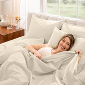 A woman is lying on a bed make with percale sheets and pillowcases