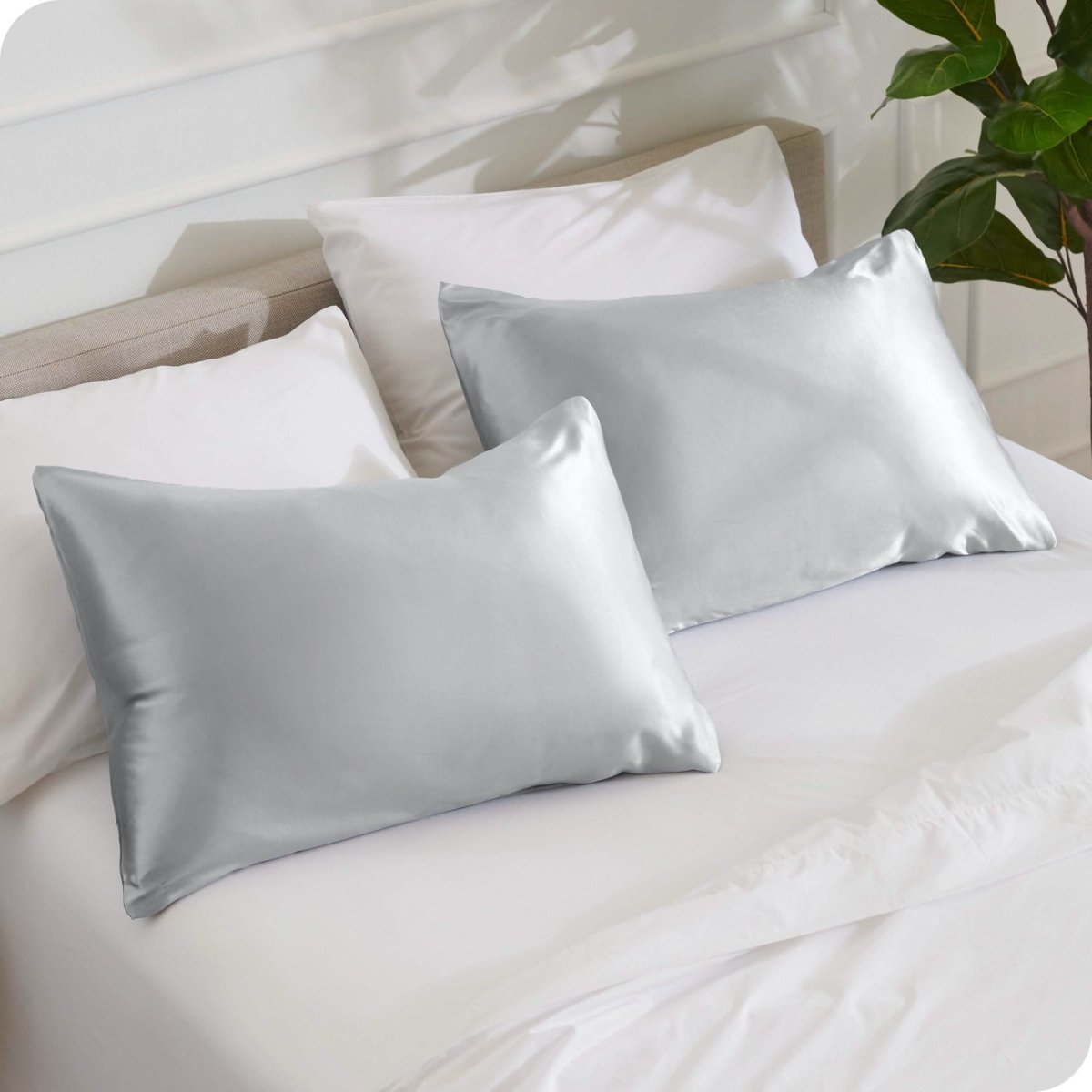 2 silk pillowcases on a bed with white linens