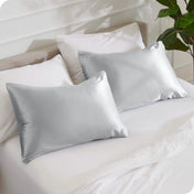 2 silk pillowcases on a bed with white linens