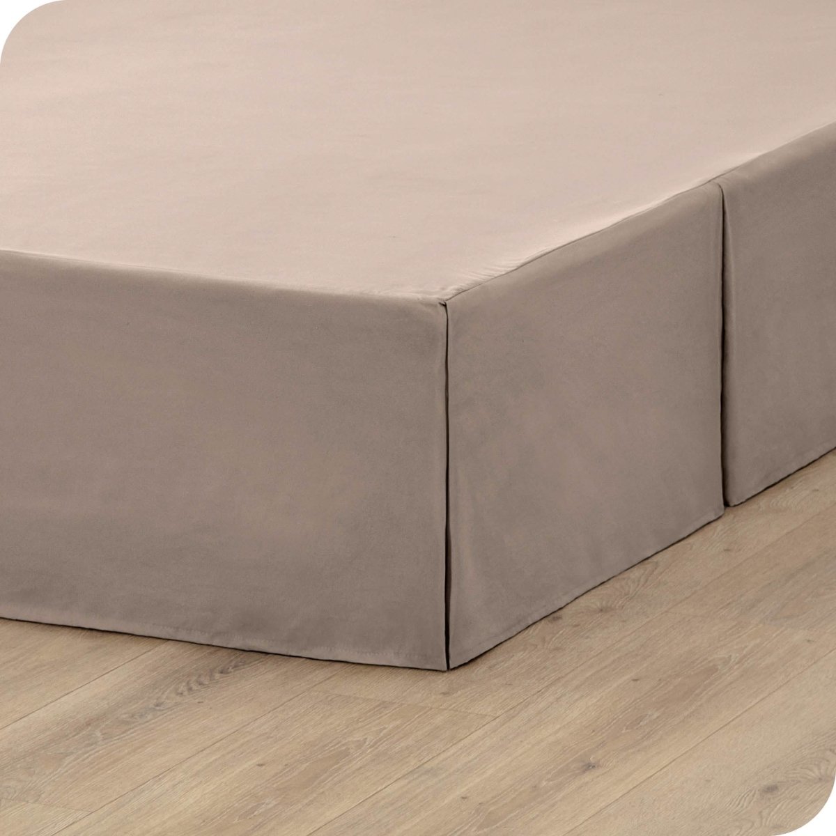 A box spring with a bed skirt on it