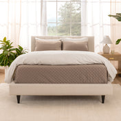 A bright bedroom with a coverlet set on the bed