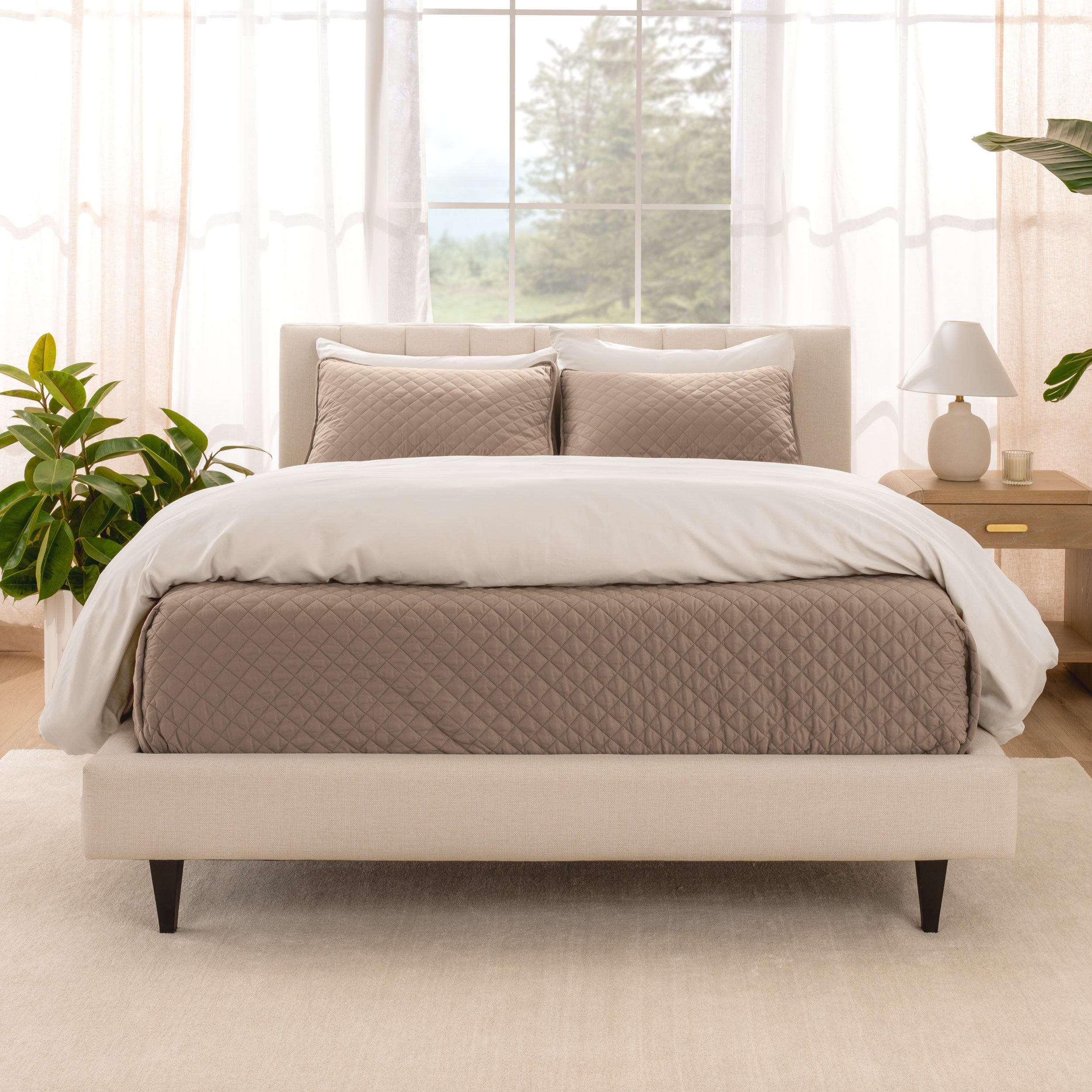 A bright bedroom with a coverlet set on the bed