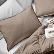 Microfiber pillow sham set on a bed with a magazine on top of the comforter.