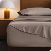 Microfiber bed sheets on a neatly made bed with a wooden headboard and nightstand.