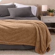 A double sided sherpa blanket on a bed