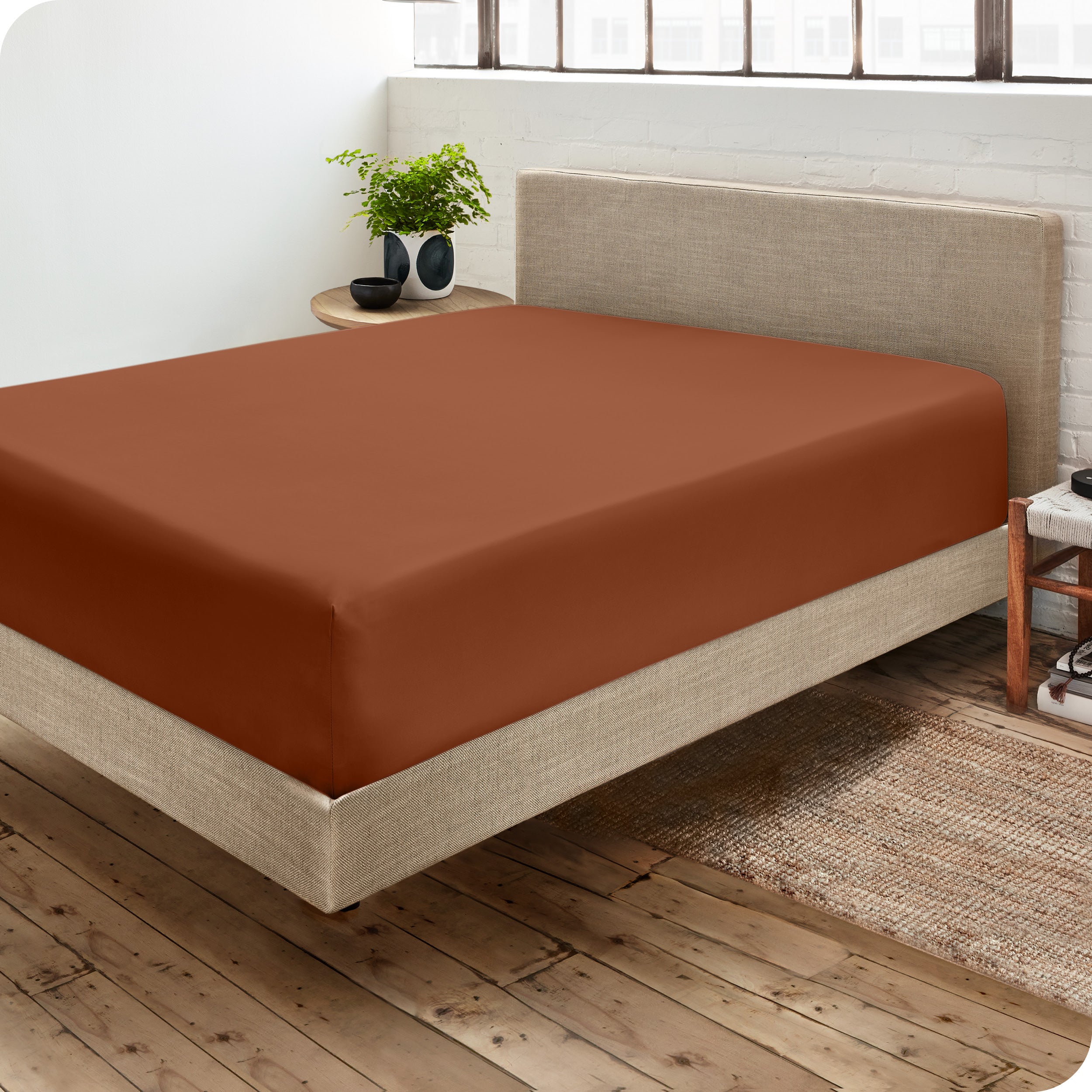 A side view of a bed made with a fitted sheet on it