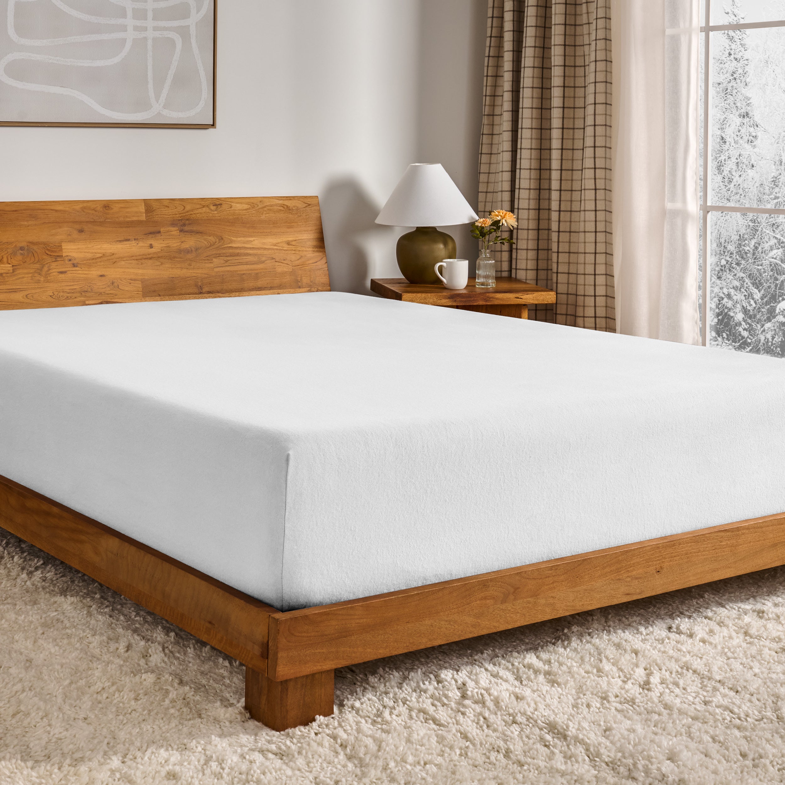 White fitted sheet on a wooden bed in a bedroom setting