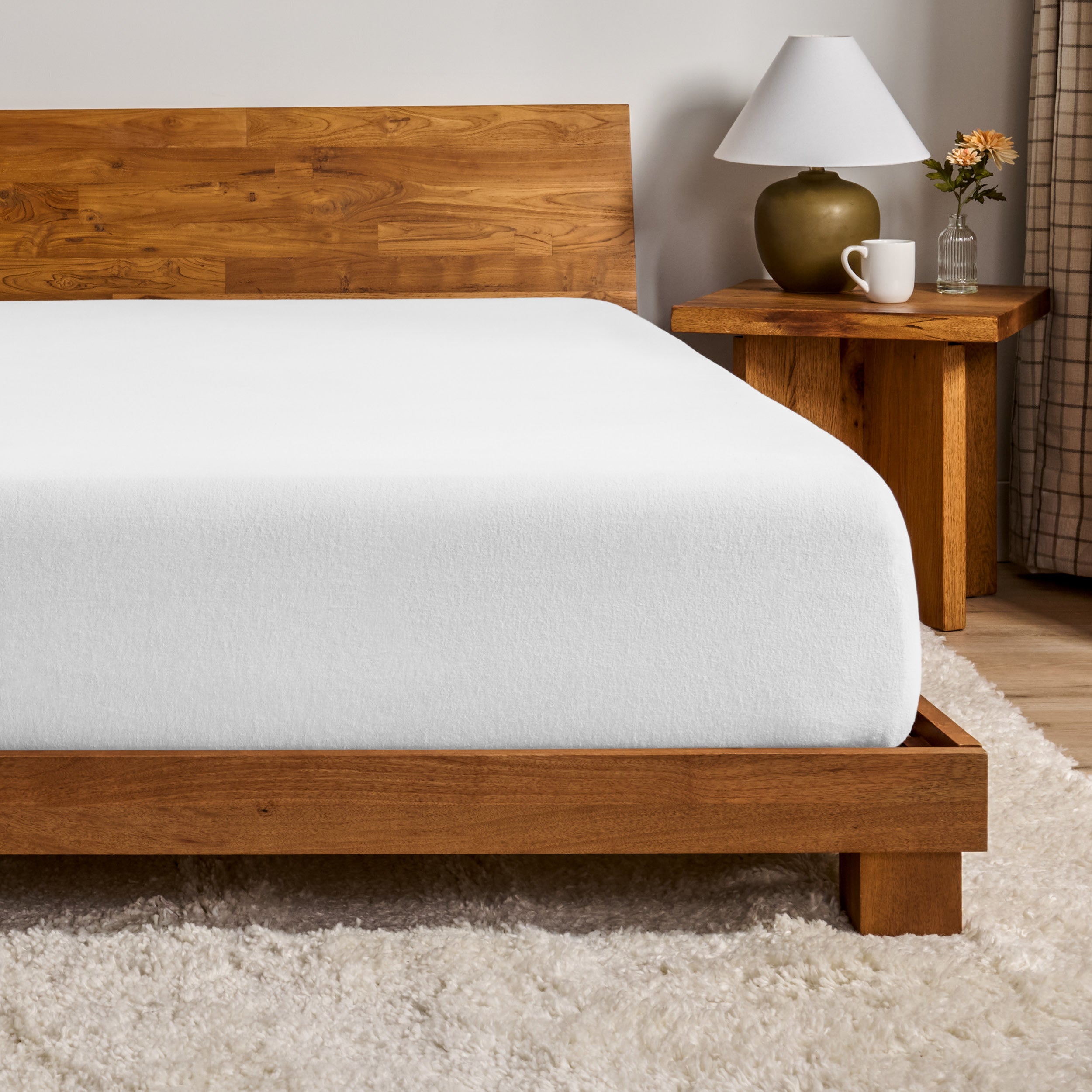 A flannel fitted sheet on a mattress with a wooden bed frame