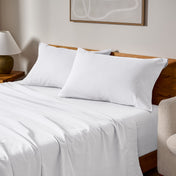 Cotton flannel sheets and pillows on a wooden bed in a bedroom setting.