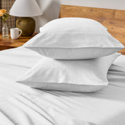 Flannel bedding set on a bed with a beige headboard and lamp.