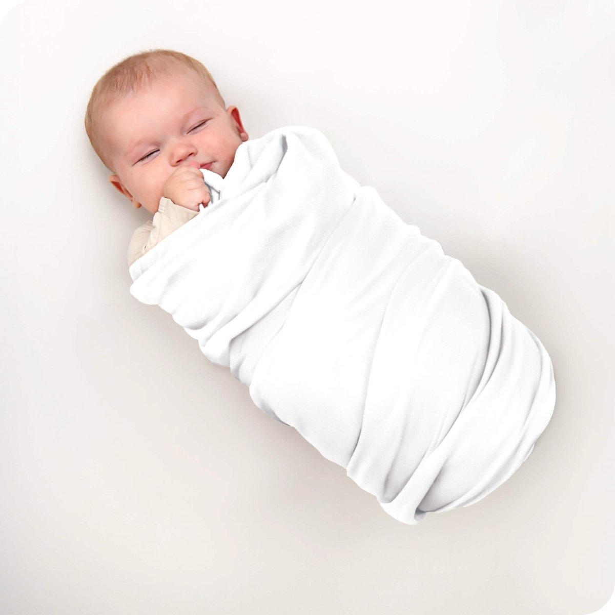 A baby swaddled in a receiving blanket