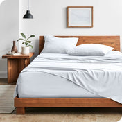 Modern bedroom with washed sheets draped over the end and the side of the bed