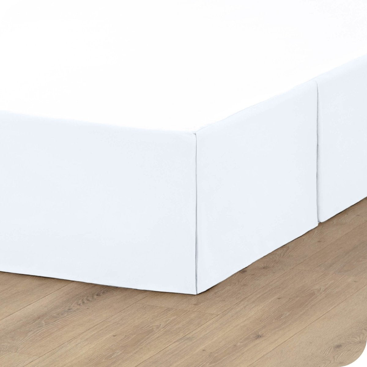 A box spring with a bed skirt on it