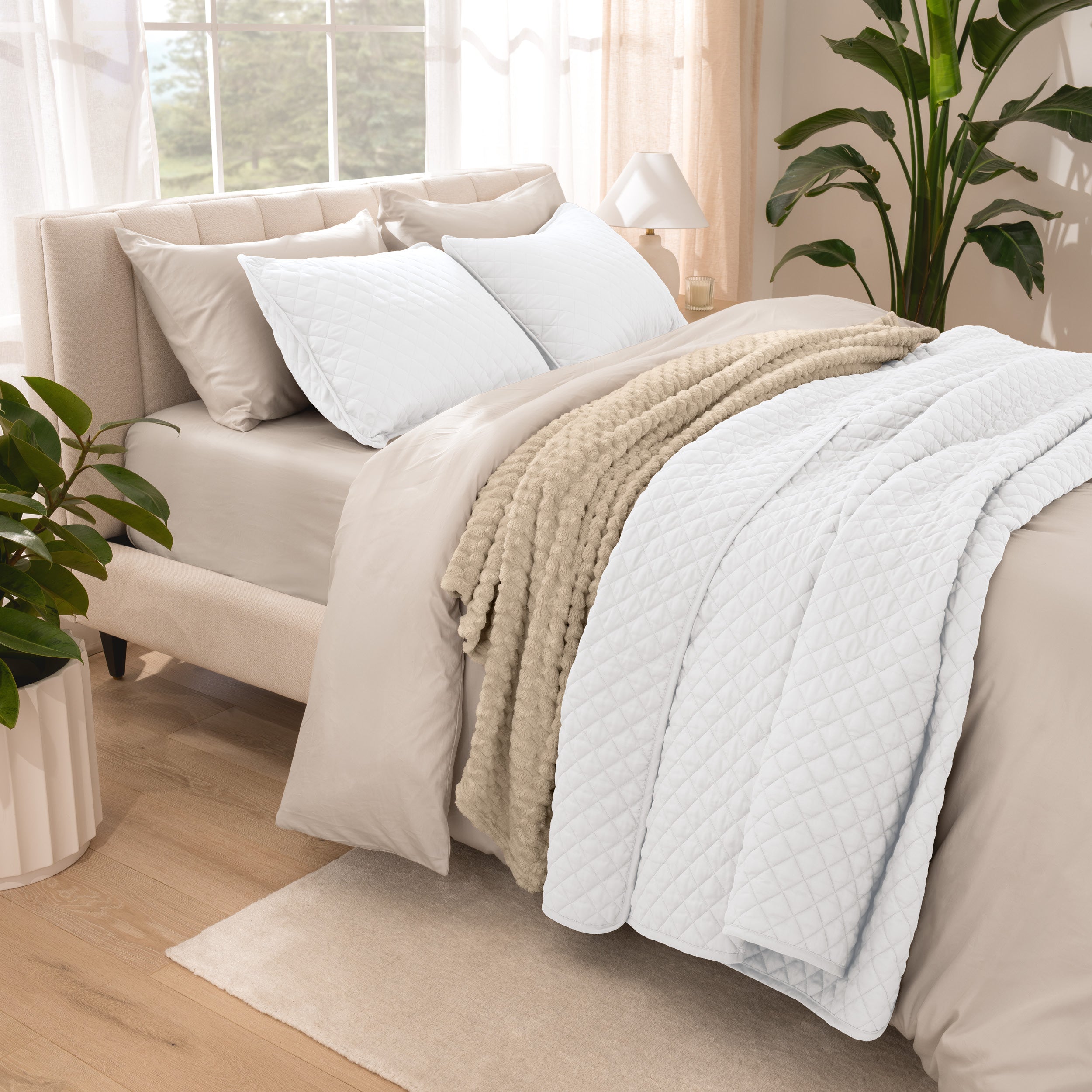 Side view of bed with coverlet set draped on a bed made with a duvet set