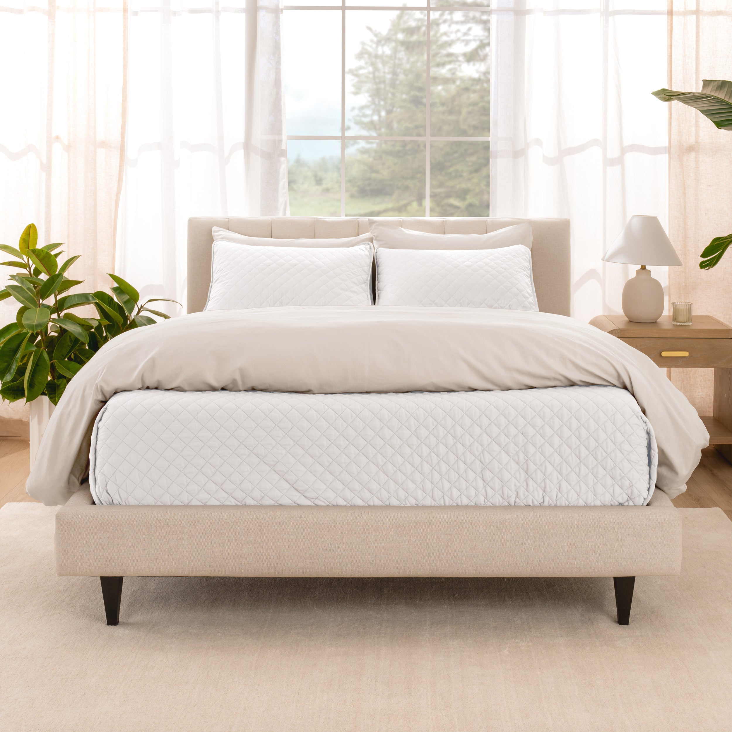 A bright bedroom with a coverlet set on the bed