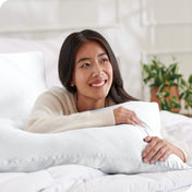 A woman is resting on a satin pillowcase covered pillow