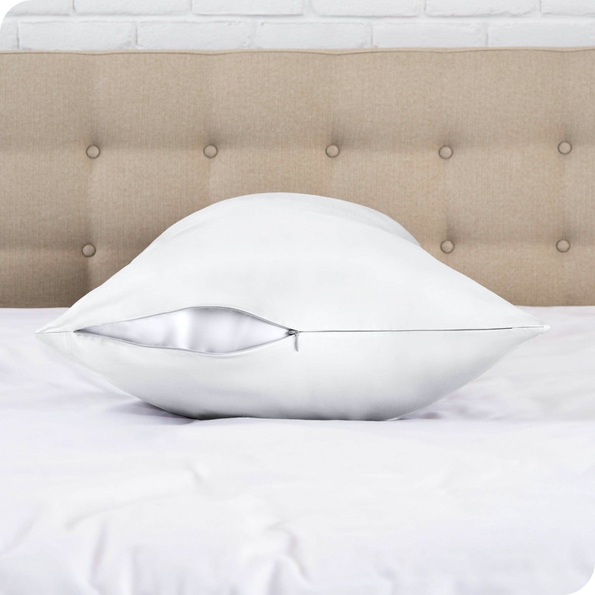 A satin body pillowcase on a bed with white linens