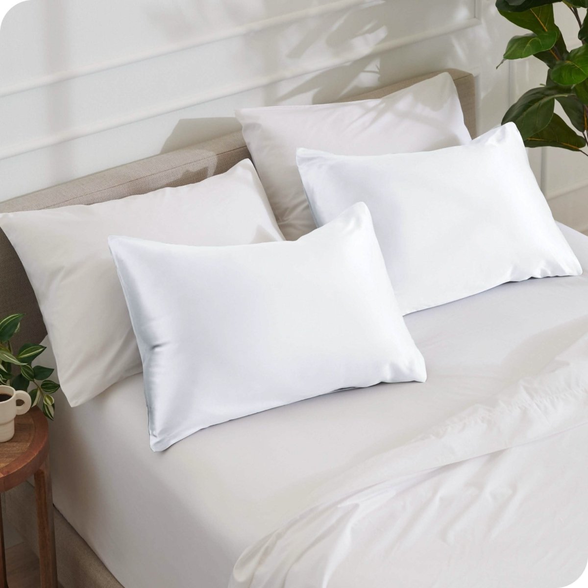 2 satin pillowcases on pillows set on a bed