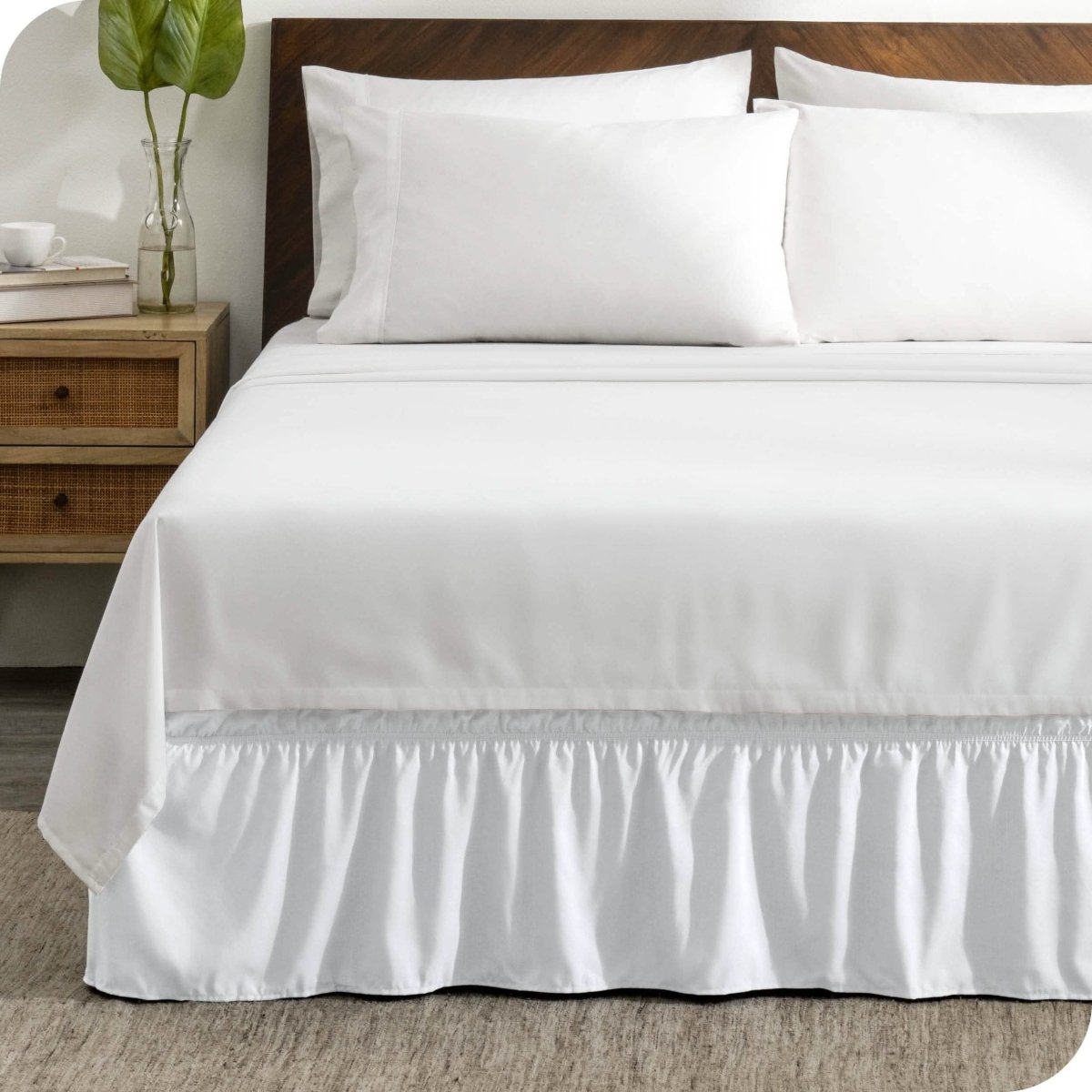 A wrap around bed skirt on a mattress with white bedding