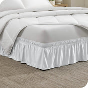 Corner of a bed with a polyester wrap around bed skirt on it