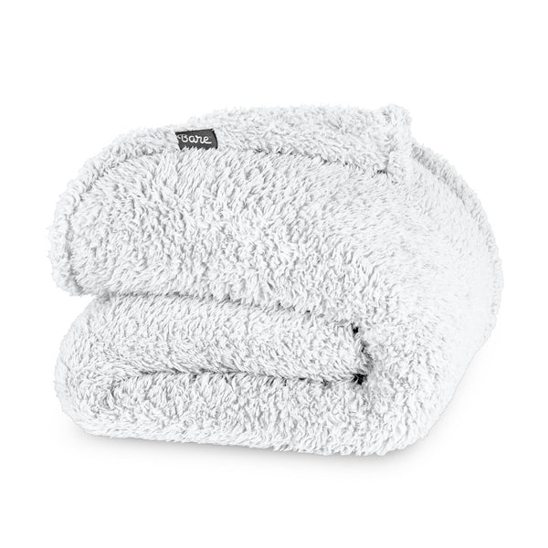 Folded textured blanket with a brand label on a white background