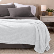 A double sided sherpa blanket on a bed