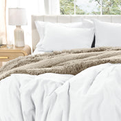Washed duvet cover set on a bed with pillows and a lamp in the background