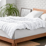 A weighted blanket draped over a bed