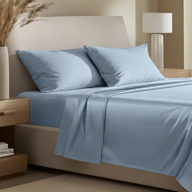 Neatly made bed with blue sheets