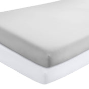 Two crib mattresses with a fitted sheets on them