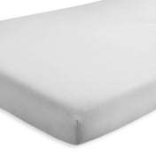 A crib mattress with a fitted sheet on it