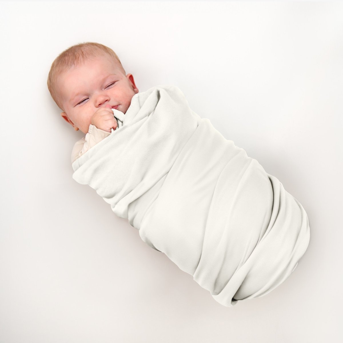 Baby wrapped in flannel receiving blanket