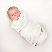 Baby wrapped in flannel receiving blanket