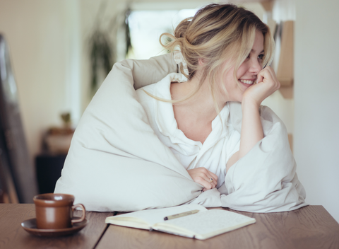 Woman sitting wrapped in a white robe, affiliate program graphic