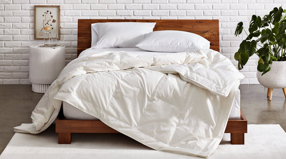 Down comforter on a mattress in a modern bedroom.