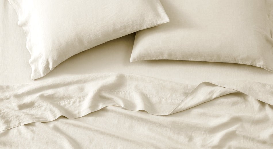 Linen sheets on a bed and linen pillowcases on pillows.