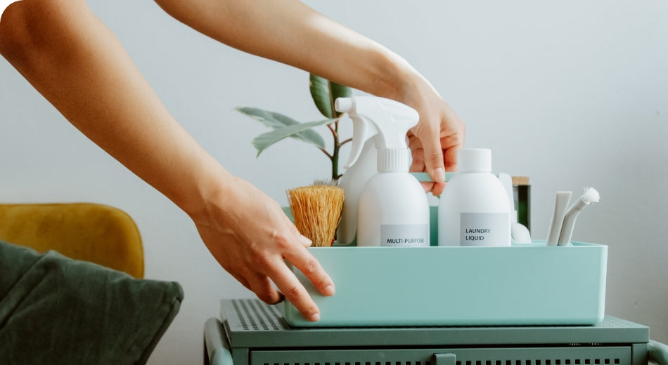 A small collection of clean products in a blue dish. A person is reaching for something inside the dish.