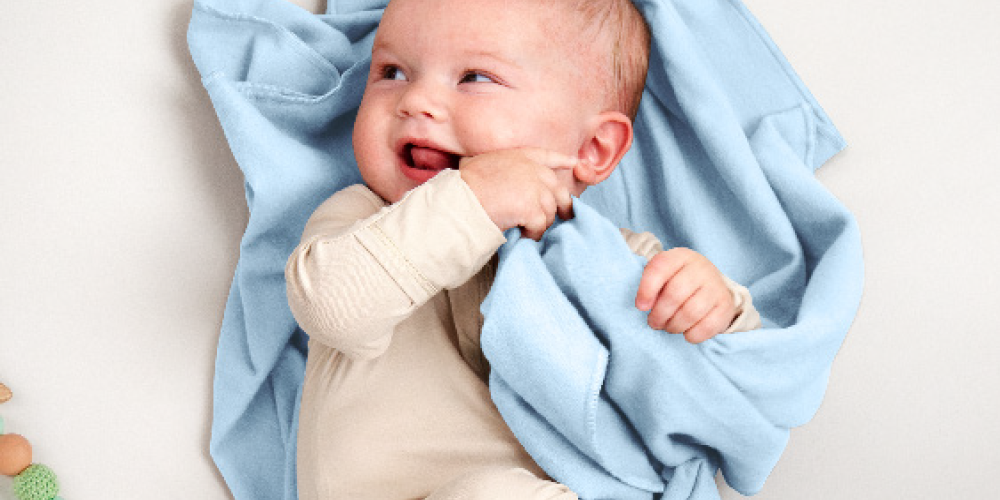 Baby wrapped in a blue and white patterned flannel receiving blanket