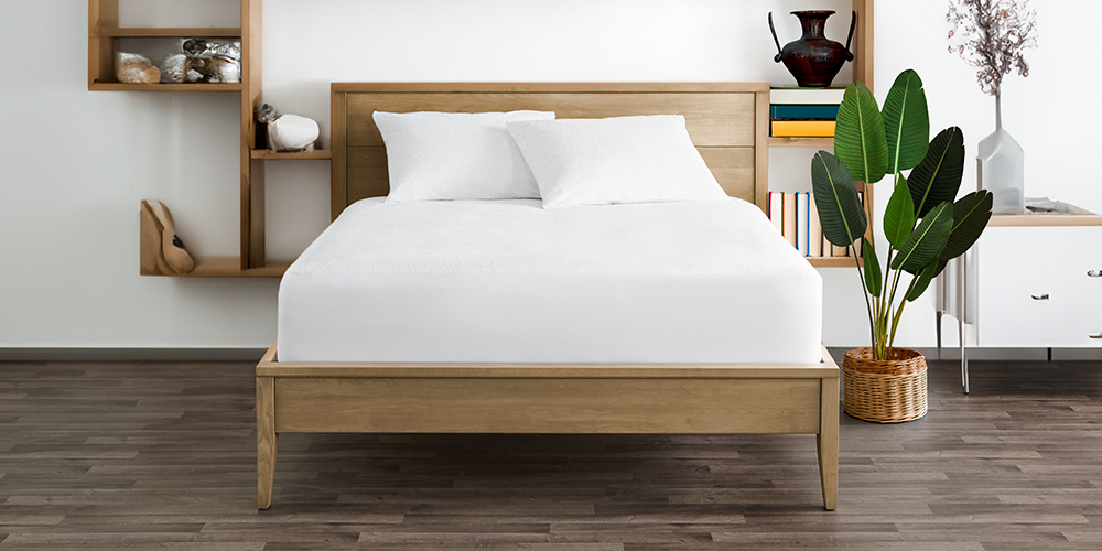 Bed styled with white Cotton Terry Mattress Protector in a bedroom