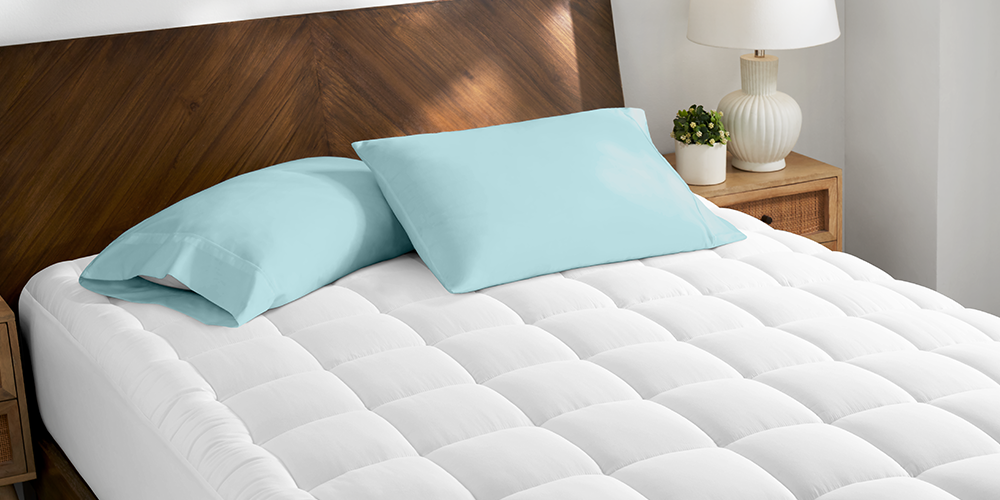 Bed styled with white Cotton Top Mattress Pad and teal pillows