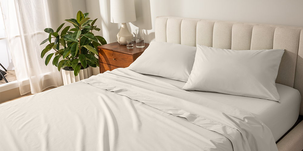 Bed styled with white Organic Cotton Percale Pillowcase Set and wood nightstand