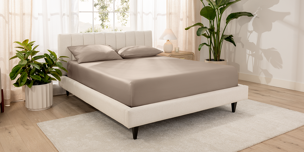 Bed styled with taupe Organic Cotton Sateen Fitted Sheet in a bedroom with plants