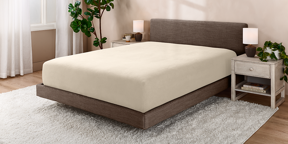 Bed styled with cream Polar Fleece Fitted sheet and wood nightstand