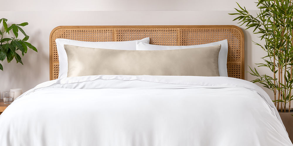 Bed with a sage green bamboo pillowcase and body pillow