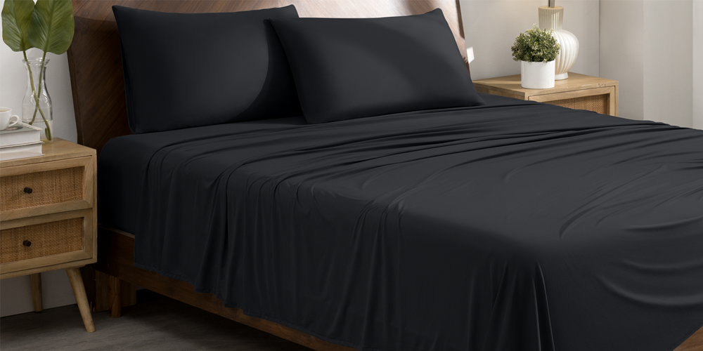 Bed with black Stretch Knit Sheet Set and wood nightstand