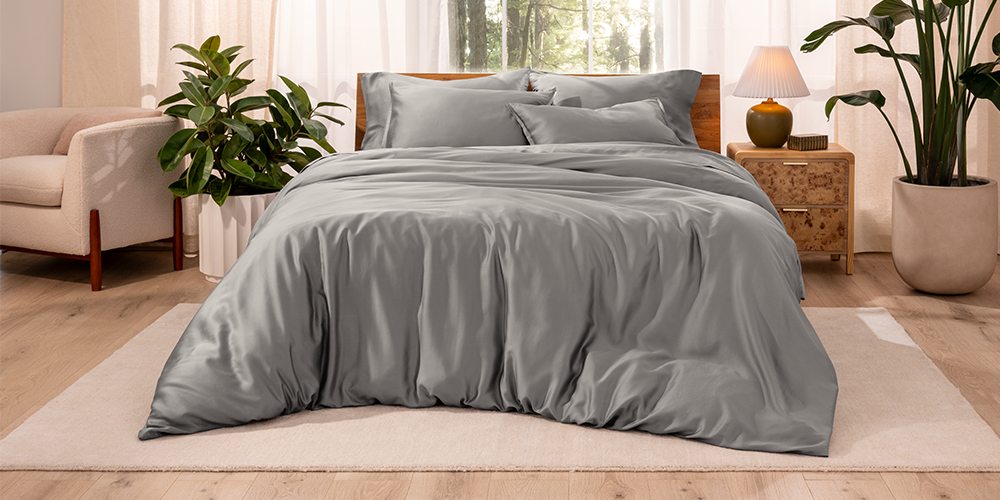 Bed styled with sage gray TENCEL Bedding Bundle in a bedroom with plants