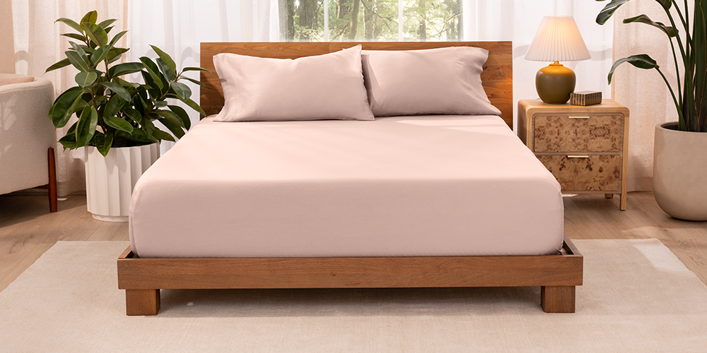 Bed styled with pink TENCEL Lyocell Pillowcase Set and wood bed frame